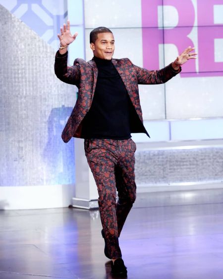 Cory Hardrict in a pink suit poses for a picture.